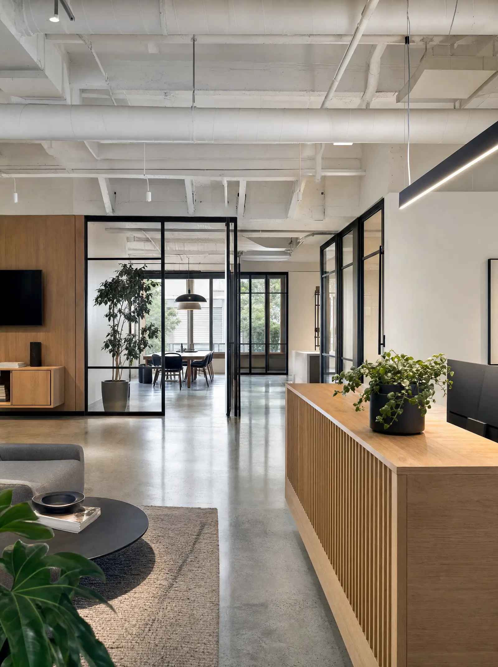 A bright commercial interior with polished concrete floors and a custom reception desk
